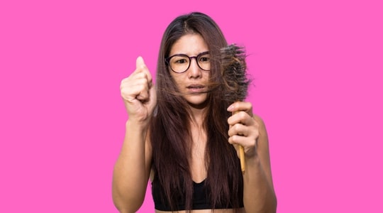 Worried woman with alopecia touching the hair from her brush